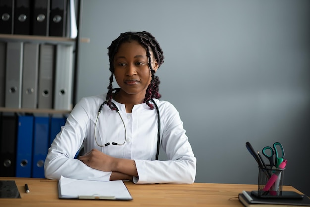 Happy young african female nurse working in office