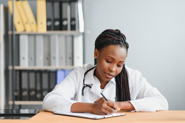 Happy young african female nurse working in office