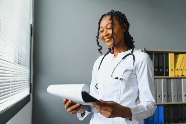 Happy young african female nurse working in office