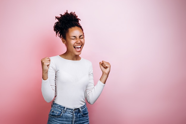 Happy young african girl make winner gesture posing