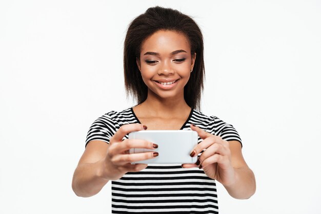 Happy young african lady make selfie by phone.