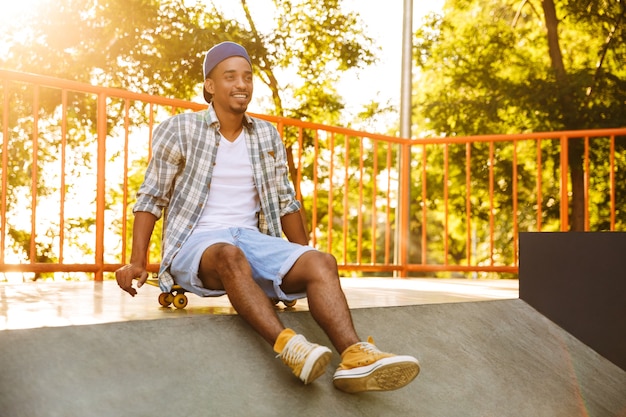 Happy young african man with skateboard