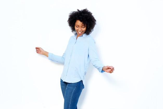 Happy young african woman dancing and enjoying against white background