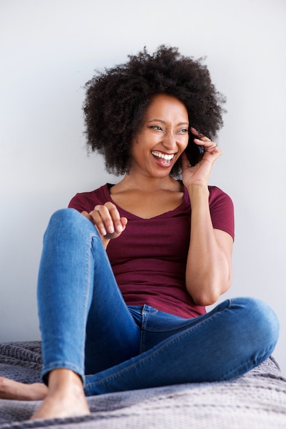 Happy young african woman relaxing and talking on mobile phone