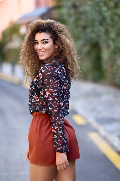 Photo happy young arabic woman with black curly hairstyle.