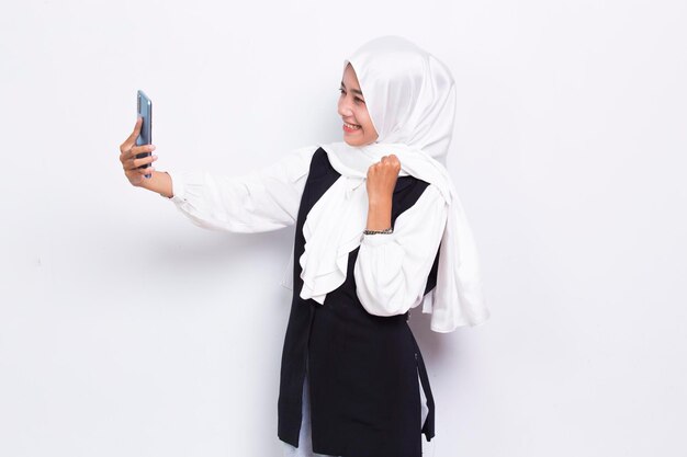 happy young asian beautiful muslim woman using mobile phone isolated on white background