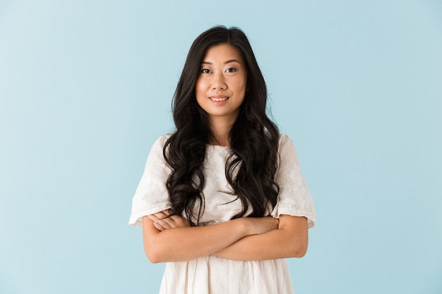 Photo happy young asian beautiful woman posing isolated over blue wall