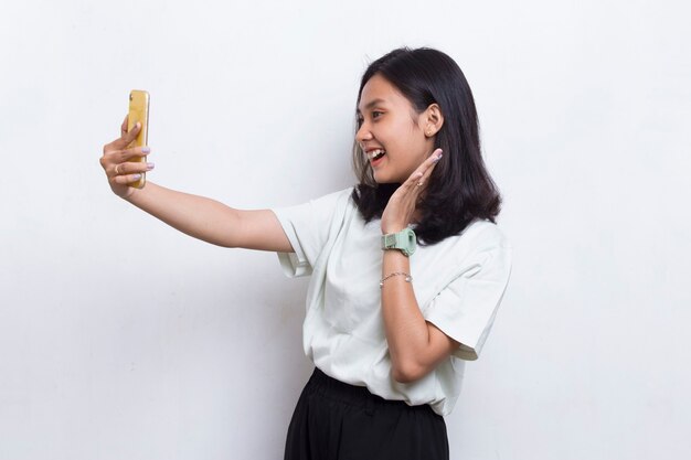 счастливая молодая азиатская красивая женщина с помощью мобильного телефона на белом фоне
