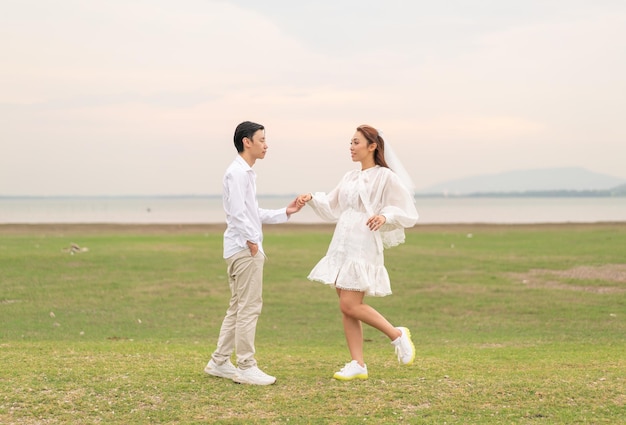 Happy young Asian couple in bride and groom clothing ready for marry and wedding celebrate