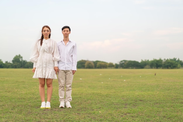 Happy young Asian couple in bride and groom clothing ready for marry and wedding celebrate