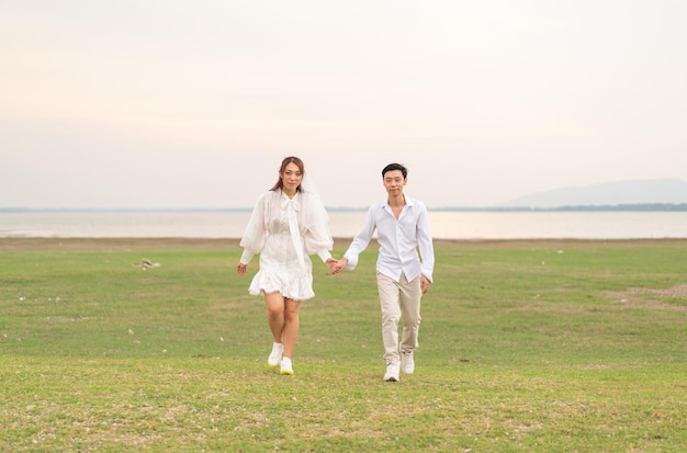 Happy young Asian couple in bride and groom clothing