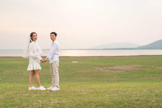 Happy young Asian couple in bride and groom clothing