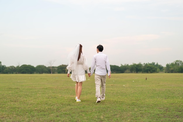 Happy young Asian couple in bride and groom clothing