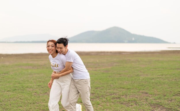 Happy young Asian couple in bride and groom t-shirt ready for marry and wedding celebrate
