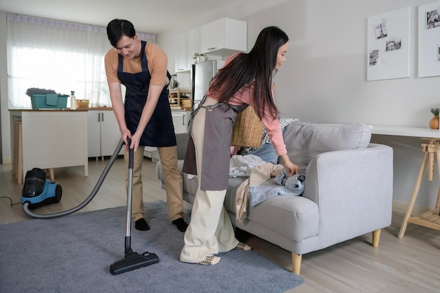 Foto giovani coppie asiatiche felici che puliscono casa insieme concetto sano di stile di vita