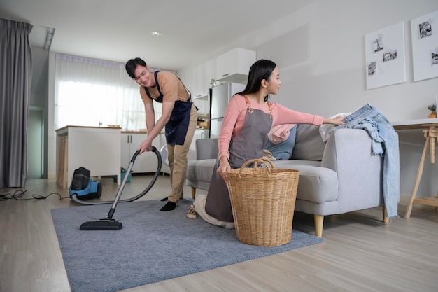 Happy young Asian couple cleaning home together healthy lifestyle concept