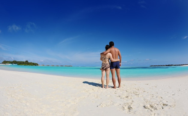 幸せなアジア人カップルが夏を楽しんで 美しい白い砂浜で