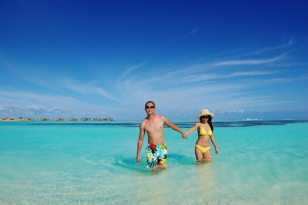 happy young asian couple enjoying summer and have on beautiful white sand beach