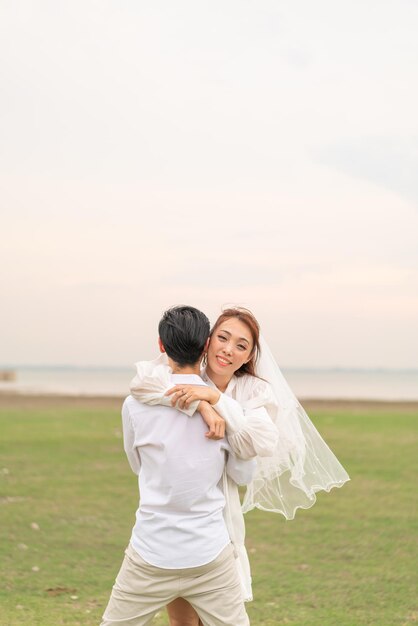 사진 결혼과 결혼을 축하할 준비가 된 신부와 신랑 옷을 입은 행복한 젊은 아시아 커플