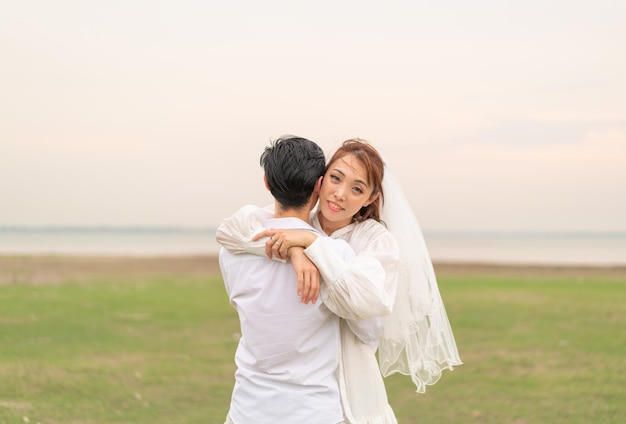 사진 결혼과 결혼을 축하할 준비가 된 신부와 신랑 옷을 입은 행복한 젊은 아시아 커플