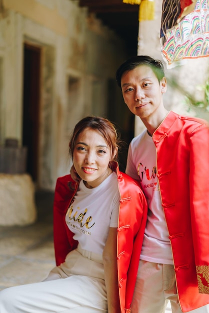 중국 전통 드레스를 입은 행복한 젊은 아시아 커플 사랑 - 빨간색은 중국의 결혼식을 포함한 전통 축제의 주요 색상입니다.