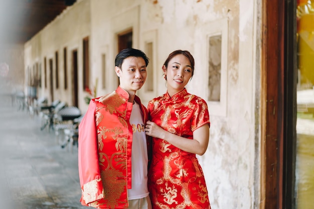 Foto felice giovane coppia asiatica amore in abiti tradizionali cinesi - il rosso è il colore principale della festa tradizionale che include il matrimonio in cina.