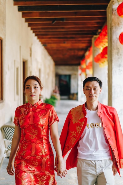 Счастливая молодая азиатская пара любит традиционные китайские платья. Красный - основной цвет традиционного праздника, включая свадьбу в Китае.