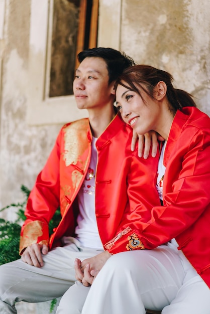 Счастливая молодая азиатская пара любит традиционные китайские платья. красный - основной цвет традиционного праздника, включая свадьбу в китае.