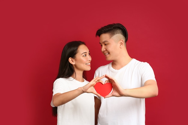 紙の心を持つ幸せな若いアジアのカップル