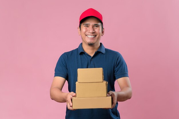 Happy Young Asian delivery man in red cap holding parcel post box