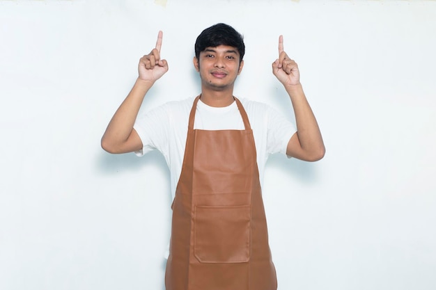 Happy young asian man barista waitress pointing with fingers to different directions on white