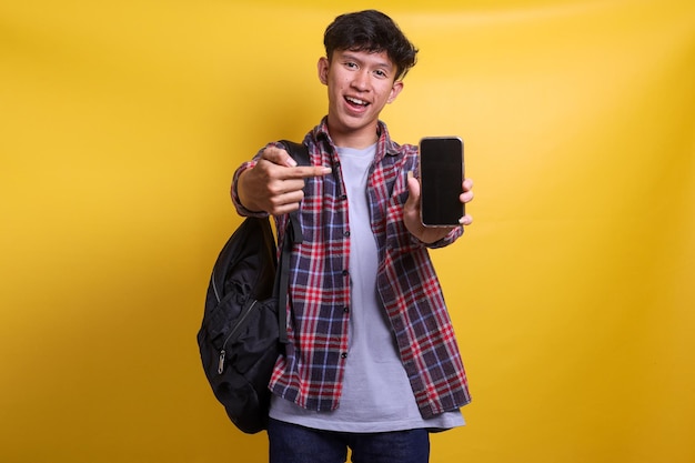 Happy young asian student man in casual style presenting blank screen smart phone for advertisment