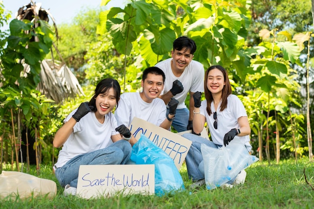 Happy young Asian students diverse volunteers hold a campaign sign for cleaning in the park