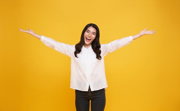 Happy young Asian teenage girl isolated on yellow background