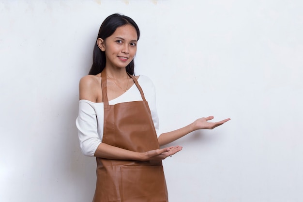 Happy young asian woman barista waitress pointing with fingers to different directions