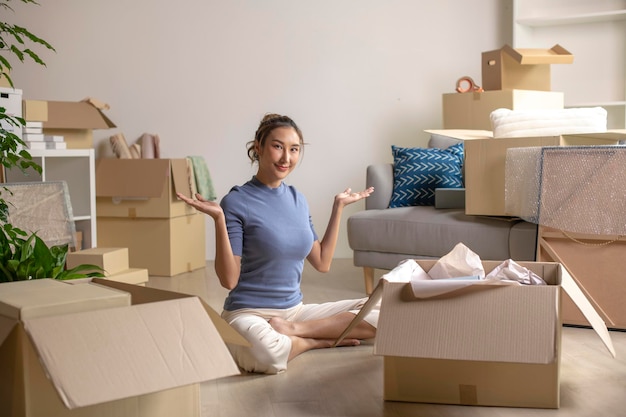 Photo happy young asian woman moving to new home smiling and looking at camera