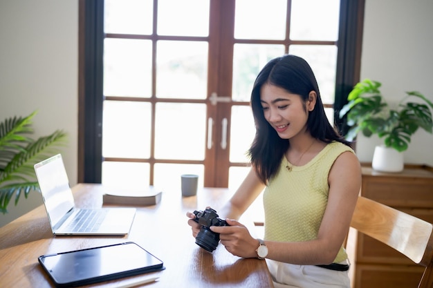 Happy young Asian Woman photographer holding camera Creative female freelancer working Blog Blogging Homepage Social Media