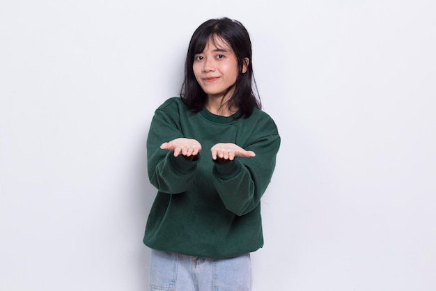 Happy young asian woman pointing with fingers to different directions isolated on white background