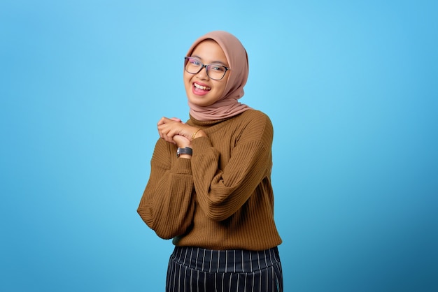 Happy young Asian woman rub hands and expect to relish on blue background