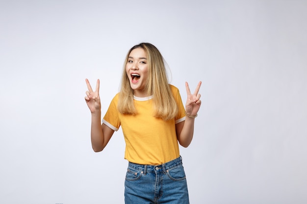 Happy young asian woman showing two fingers or victory gesture