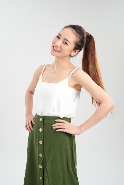 Happy young Asian woman standing over white background