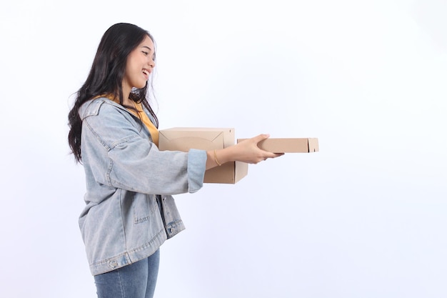 Photo happy young asian woman wearing blue jacket yellow tshirt holding and giving package parcel boxes