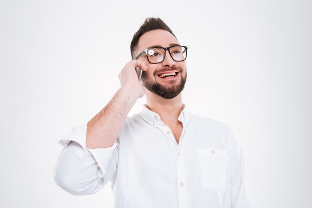 Photo happy young bearded man talking by phone