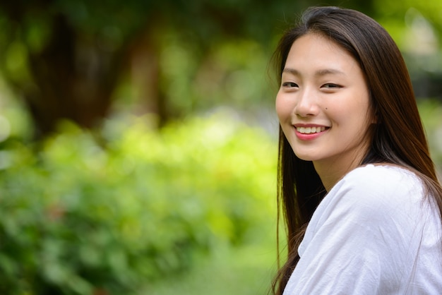 공원에서 행복 한 젊은 아름 다운 아시아 십 대 여자