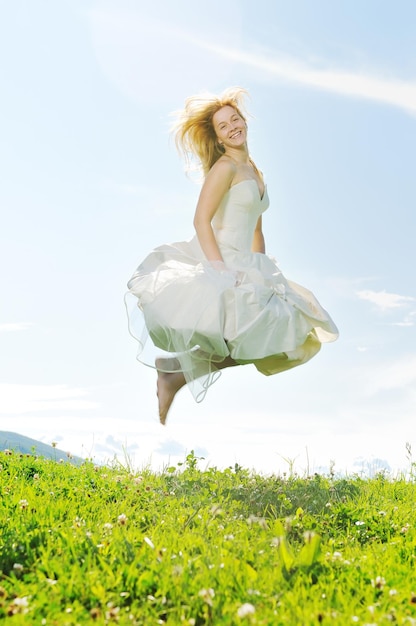 happy young beautiful bride after wedding ceremony event have fun outdoor on meadow at sunset