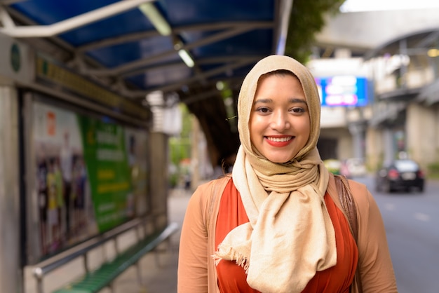 버스 정류장에서 웃고 행복 한 젊은 아름 다운 인도 무슬림 여성