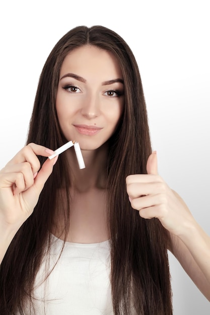 Happy young beautiful woman holding a broken cigarettequit smoking conceptution