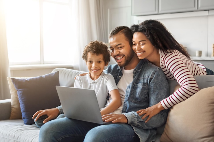 Photo happy young black family of three using laptop together at home