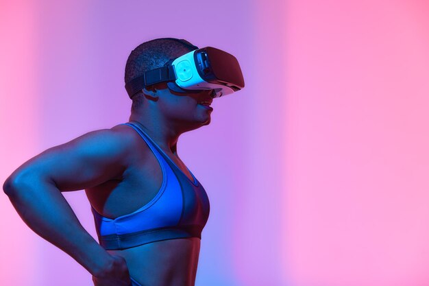 Happy young black lady in vr glasses exploring cyberspace touching imaginary screen playing virtual