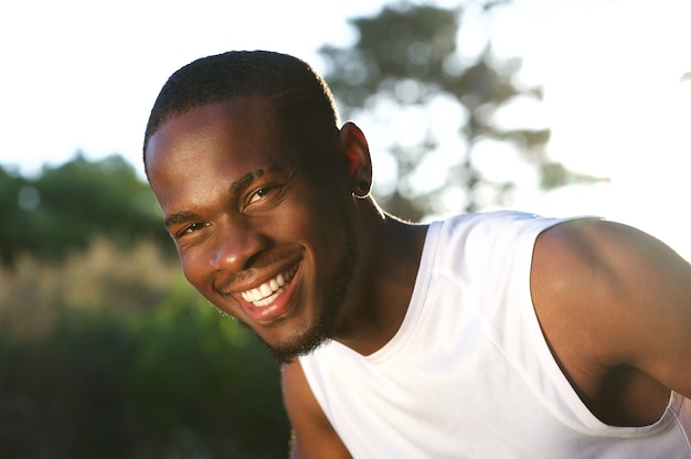 Happy young black man smiling outdoors